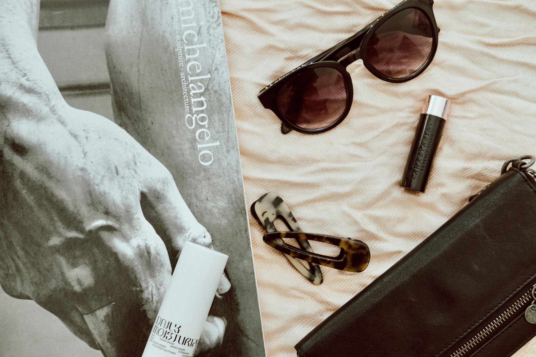 Stylish fashion accessories on display with a Michelangelo artwork in the background, creating a chic flat lay. — Top Wedding
