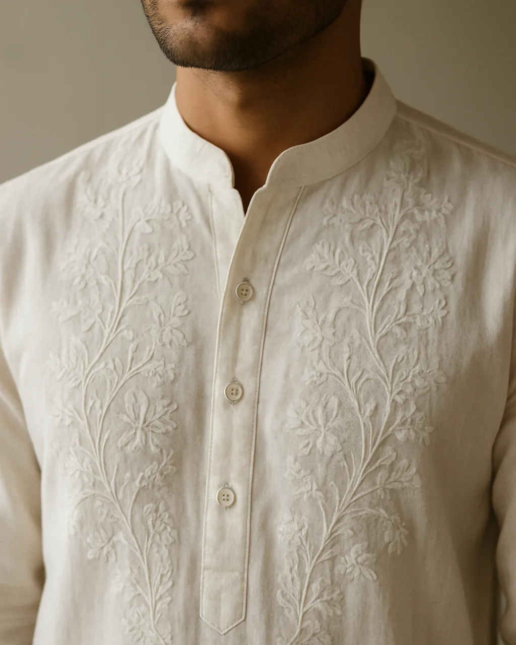 Close view of white chikan embroidery on a men's cotton kurta